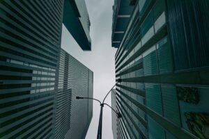 Dramatic view of modern skyscrapers in New York City against a cloudy sky.
