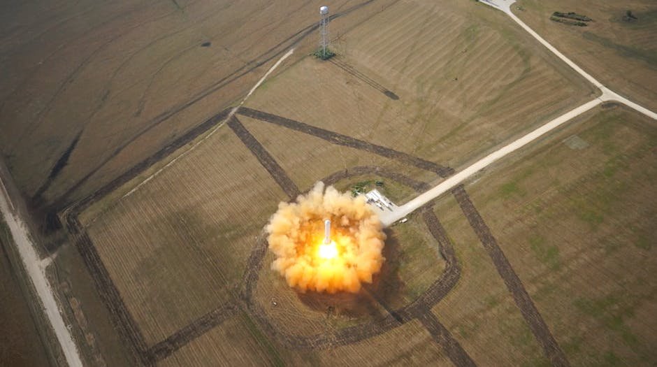 A dramatic aerial shot capturing a rocket's liftoff from a launchpad in open fields.