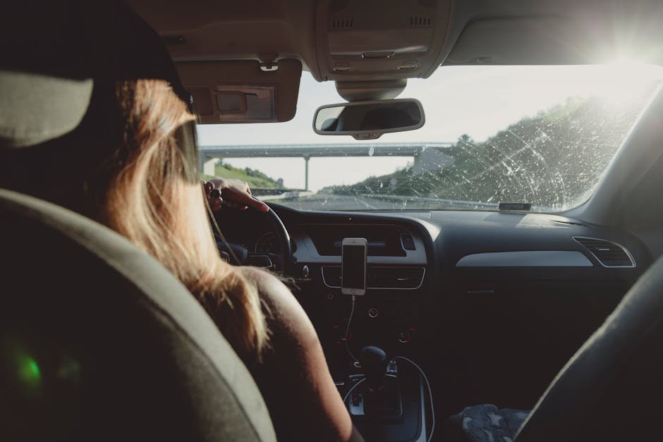 Woman driving on a highway during daytime, capturing road trip mood.