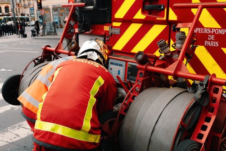 Firefighters using equipment on a fire truck in Paris, ensuring public safety.