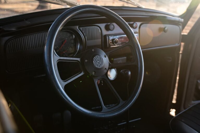 Interior view of a vintage Volkswagen Beetle featuring its iconic steering wheel. Classic car enthusiasts' delight.