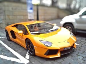 Yellow sports car on a cobblestone street, showcasing sleek design and vibrant color.